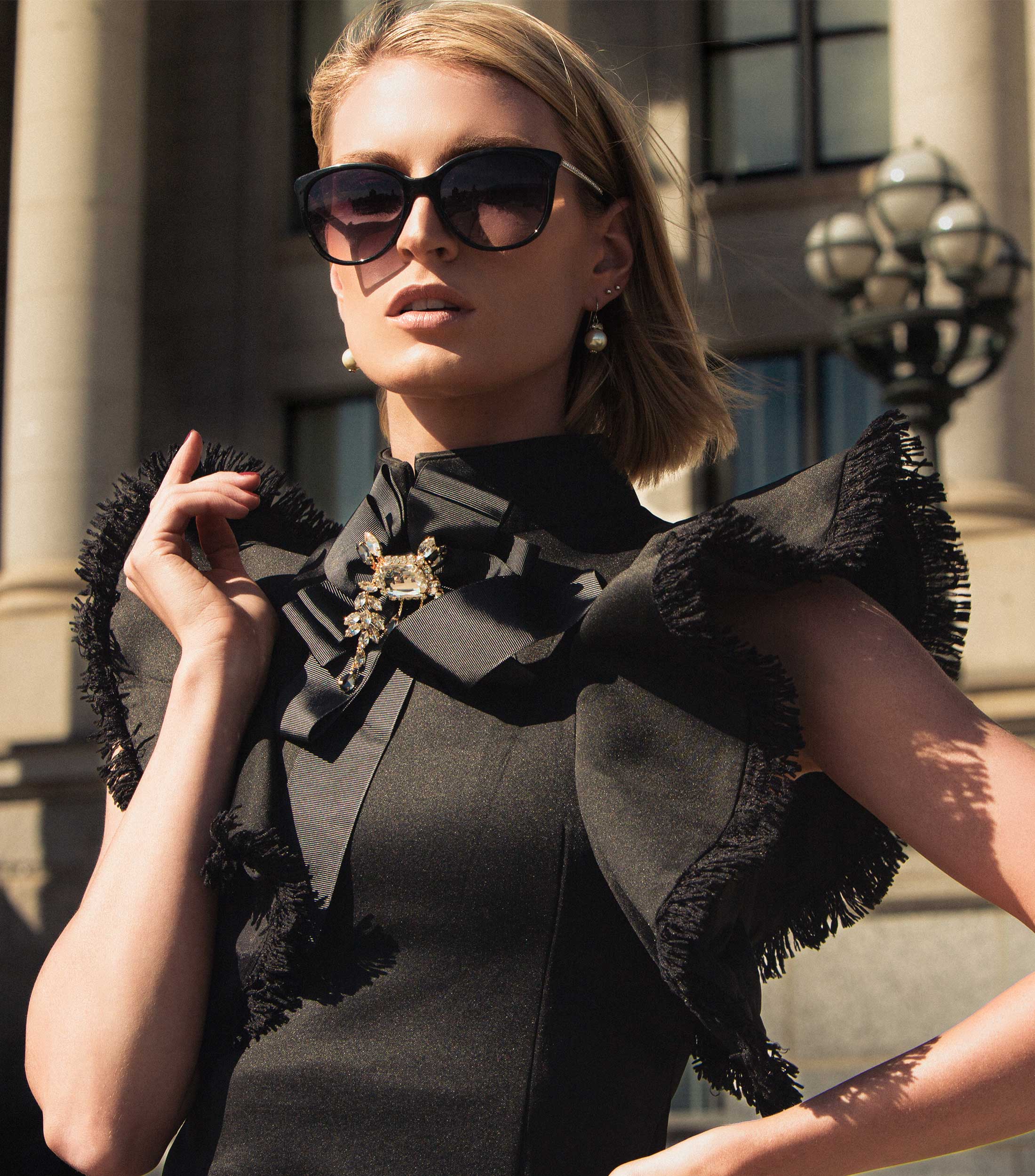 Contemporary editorial fashion portrait with structured garment refinement and architectural background – Figura Contemporanea direction by ANGOMAN Editorial Studio